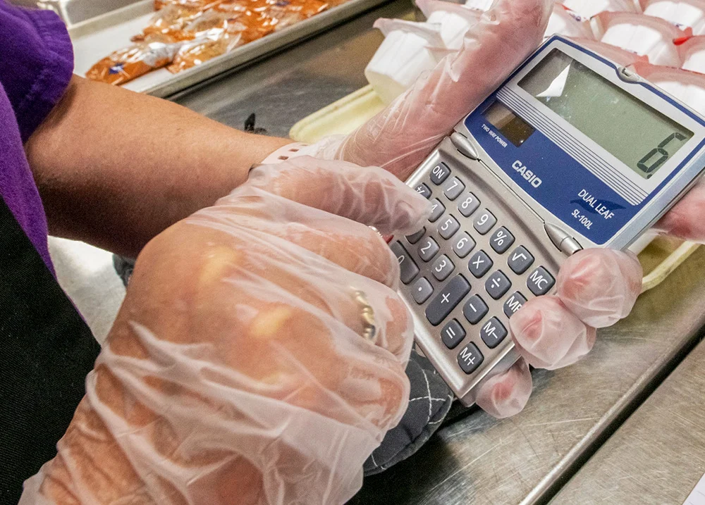 Hand entering numbers on a calculator