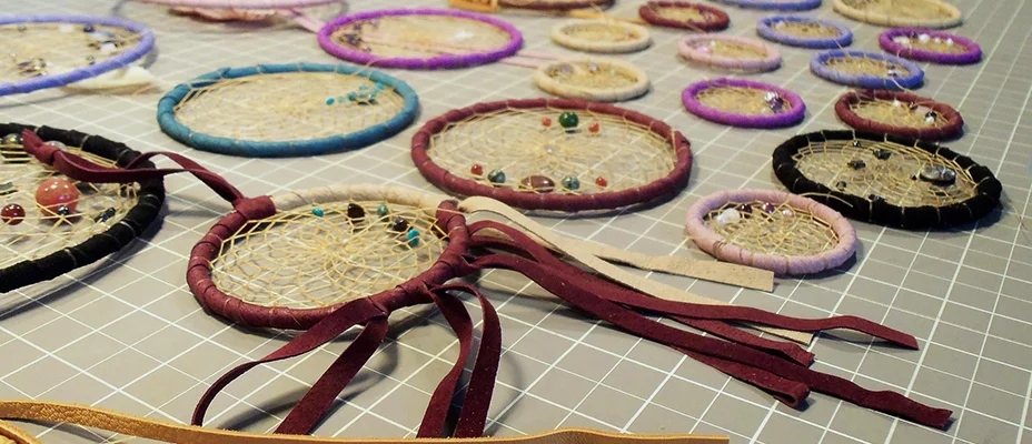 Dream catchers being made, laying on a sewing mat