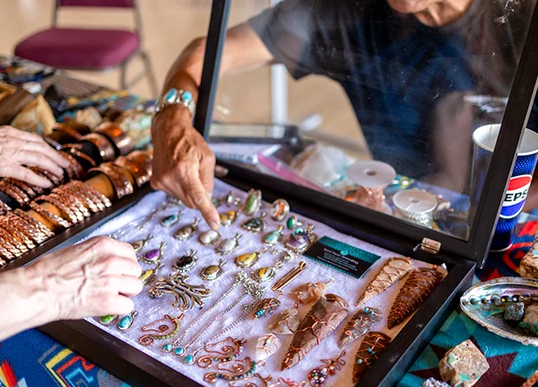 Person selling jewelry at vendor table