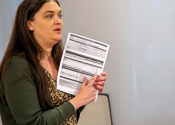 Woman standing and pointing at something on a paper form