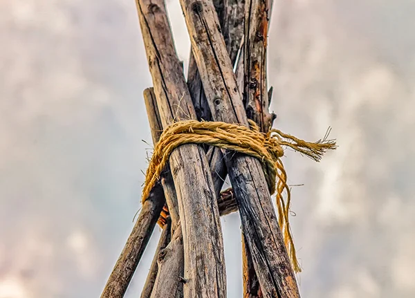 Large wood poles wrapped together with rope