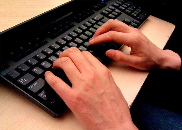 Hands typing on a computer keyboard