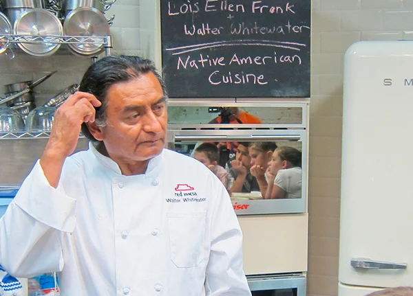 Chef standing in a kitchen looking to the side