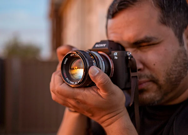 Man looking into camera and focusing the lens