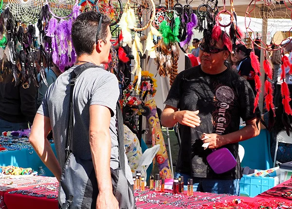 Vendor and a customer at a booth selling dream catchers