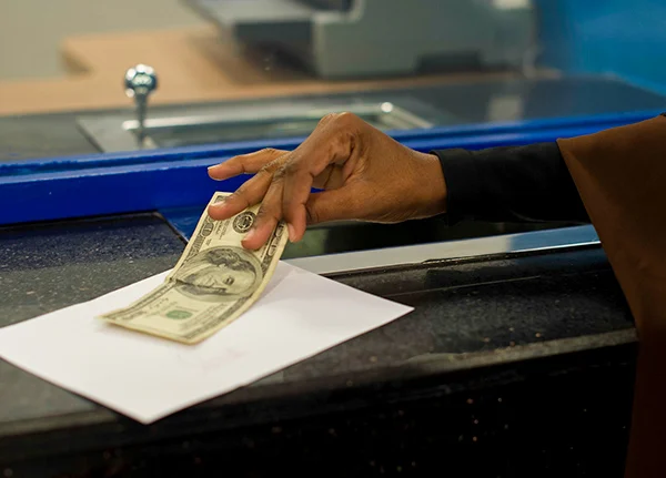 Hand grabbing a one hundred dollar bill