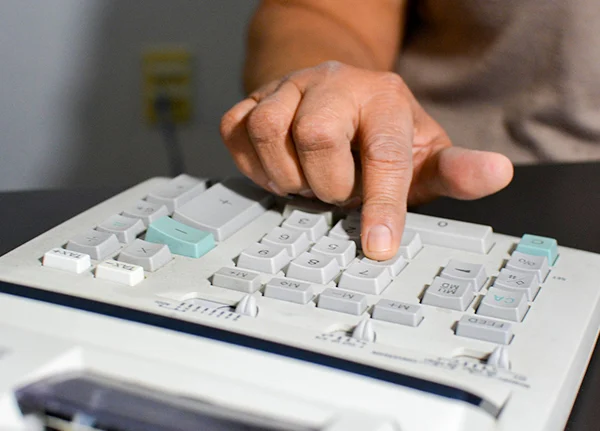 Hand punching numbers on a calculator