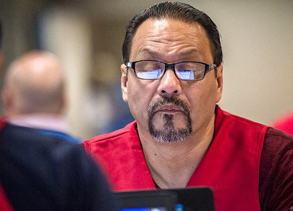 Man glancing down at a laptop screen