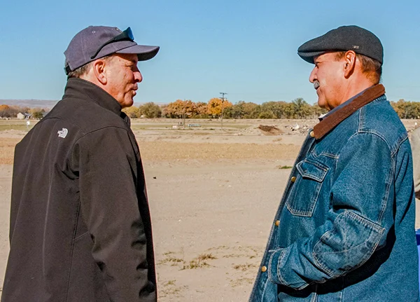 Two men talking in field