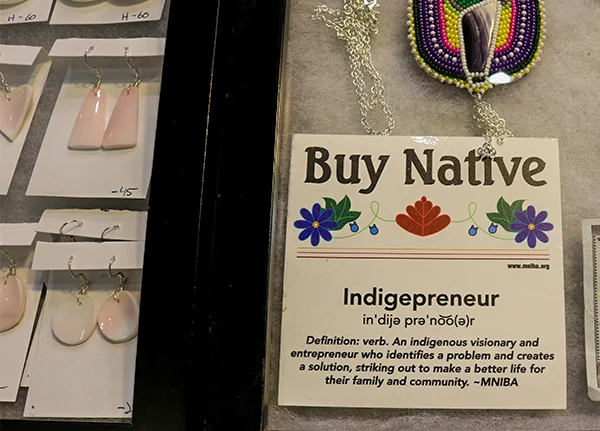 Sign that says Buy Native next to earrings