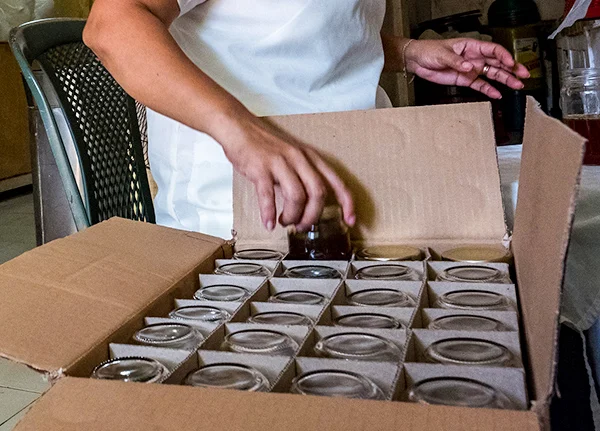 Person puts jars in a box