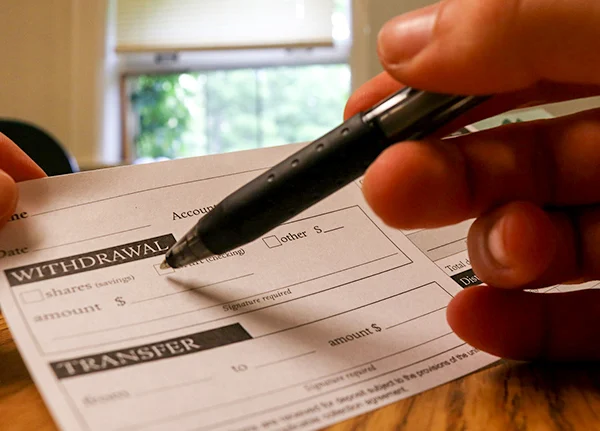 Person filling out deposit slip