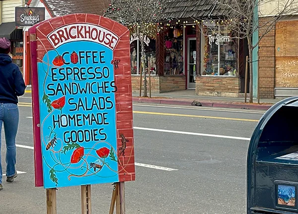 Sign advertising a coffee shop on the sidewalk