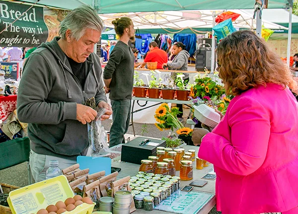 Woman buying goods from a vendor at an outdoor market