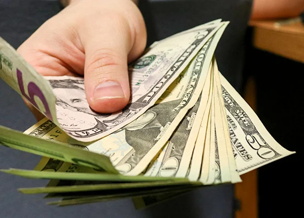 Hand holding a small fan of cash