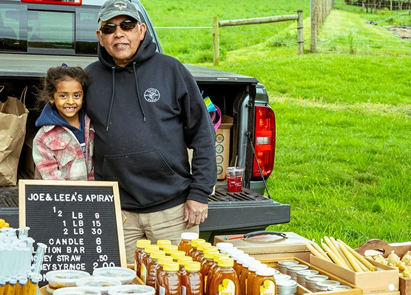 A man and his young daughter selling honey