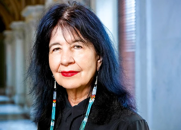 Woman with long beaded earrings smiles at the camera