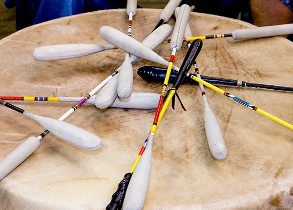 A large drum with drum mallets lying on top of it