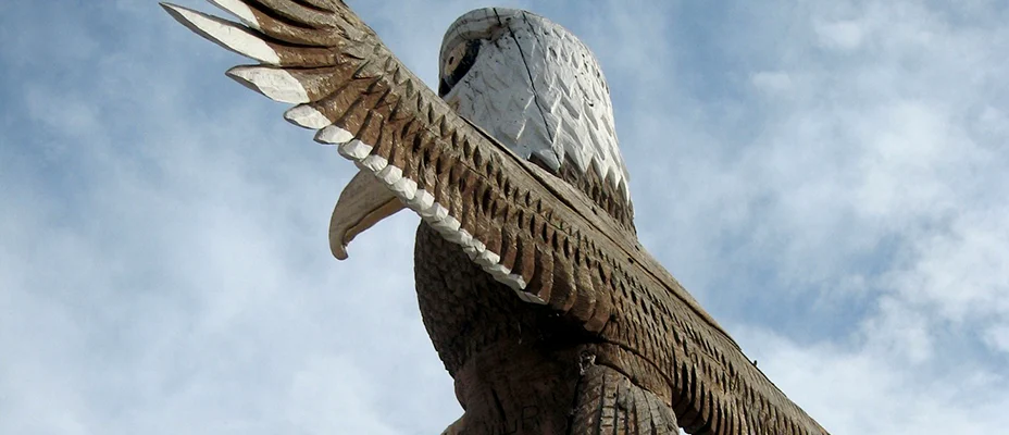 Totem pole with a carved eagle with outstretched wings at the top