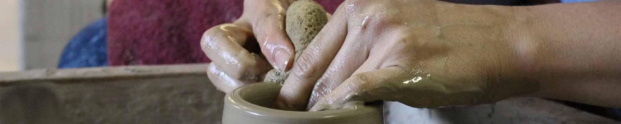 Close-up of hands forming clay on a wheel