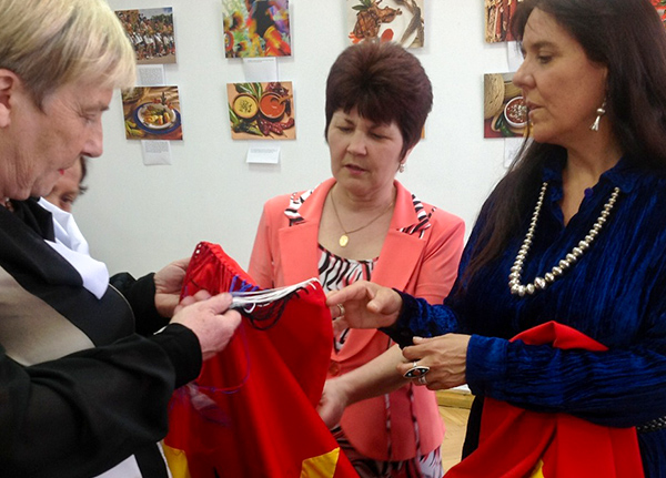 Small group of women inspecting a hand-sewn article of clothing