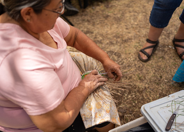 Woman creating a woven design with grasses