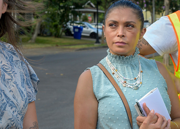 Woman holding a notepad and looking at someone out of frame