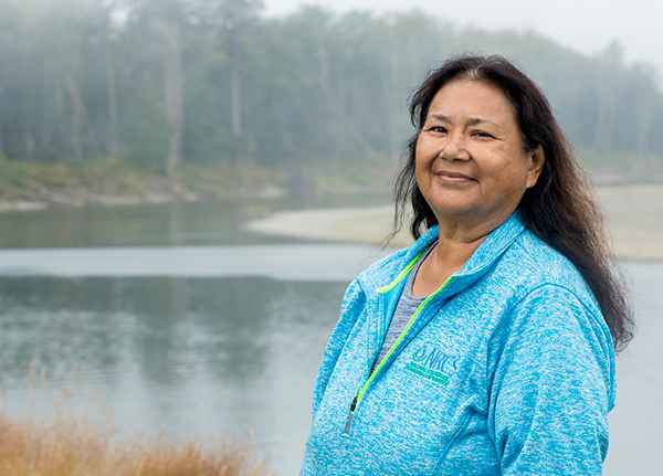 Woman standing and smiling with a river in the background
