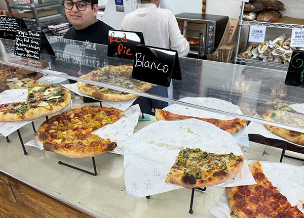 Pizzas behind glass at a buffet-style restaurant
