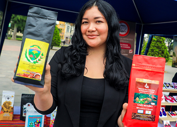 Woman holding small bags of coffee at a market