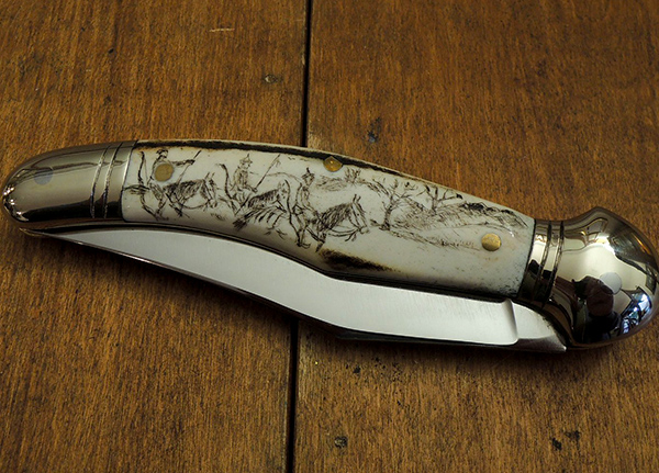 Folding knife with engravings in an antler handle