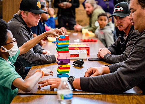 A group of people play Jenga
