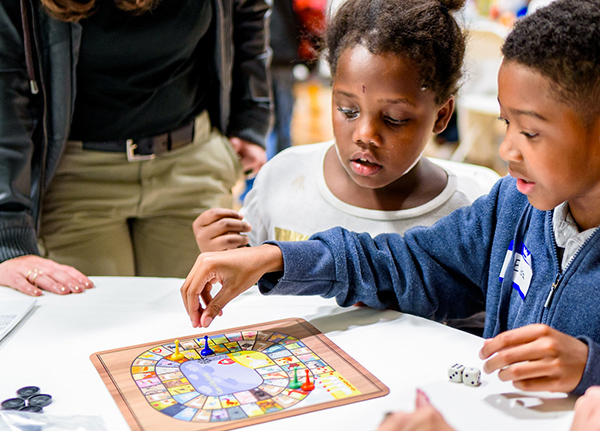 Two young kids playing a board game