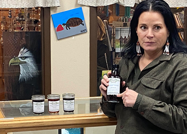 Woman holding and pointing at a jar of sauce