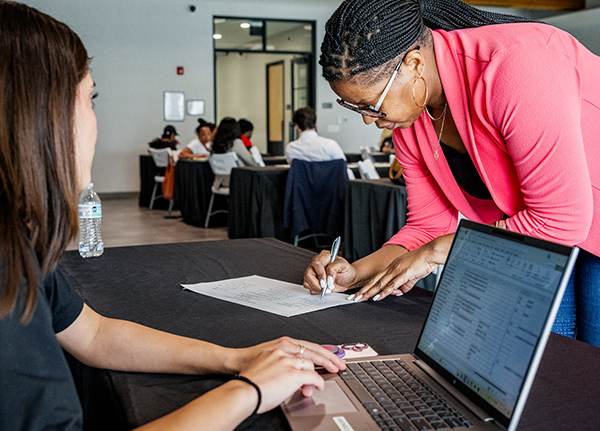 Woman filling out a piece of paper at a vendor table