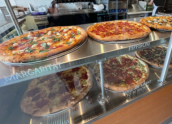 Pizzas on display in a glass case