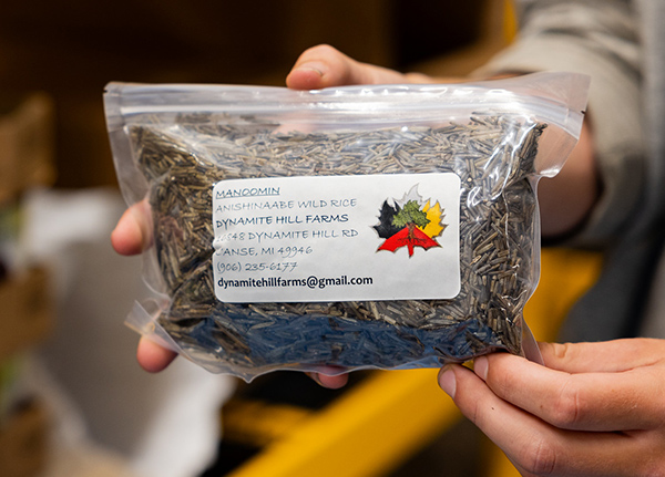 Person holding a bag of wild rice with a printed label