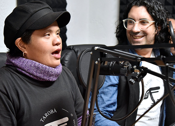 Person talking into a microphone at a recording studio