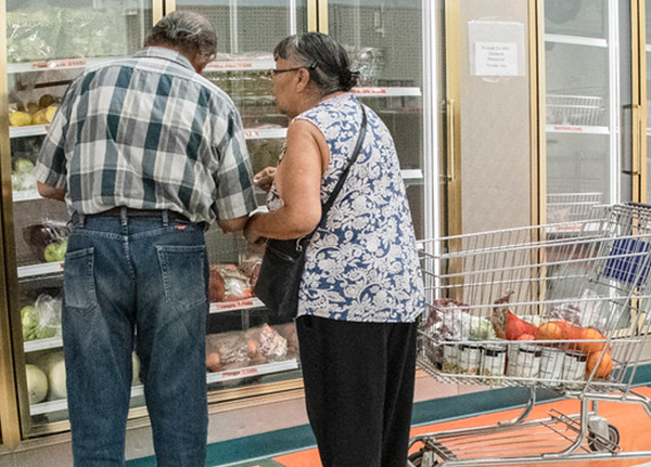 Two older people shopping at a grocery store