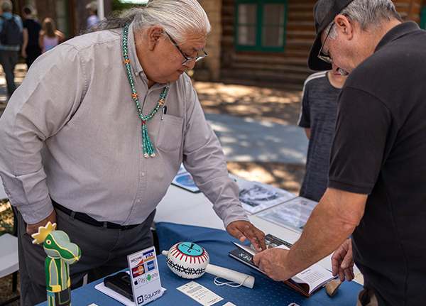 Man selling products to a customer at an outdoor booth