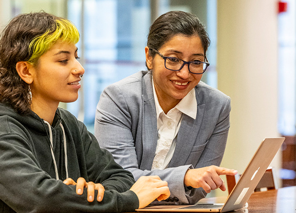 Two people looking at a laptop