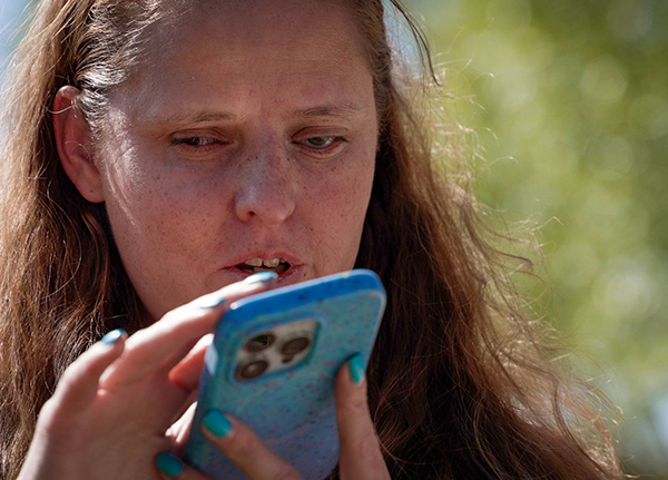 Woman with a visual impairment speaking into a smart phone