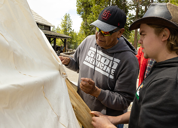 Two men looking at a tipi canvas