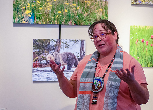 Woman standing in front of printed landscape photographs