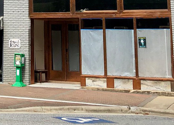 A vacant building with covered up windows