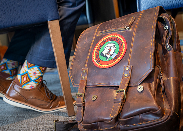 A leather laptop bag with a tribal logo on it