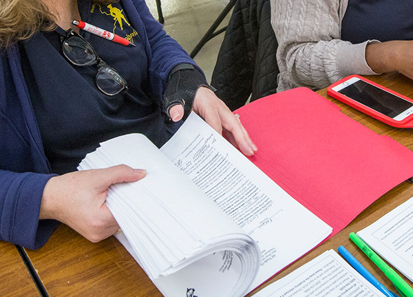 Person flipping through papers in a folder