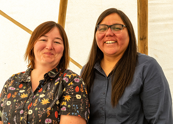 Two women stand and smile at the camera