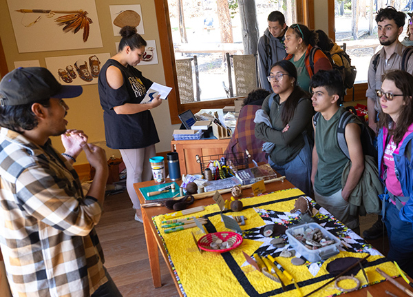 A man talking to a group of students in a shop