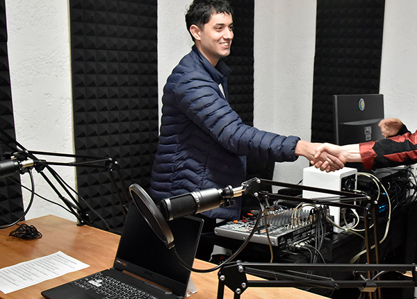 Man in a recording studio shaking someone's hand